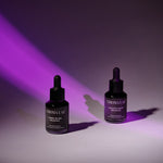 Two black dropper bottles with purple labels on a white background