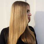 Woman with long, straight blonde hair against a neutral background