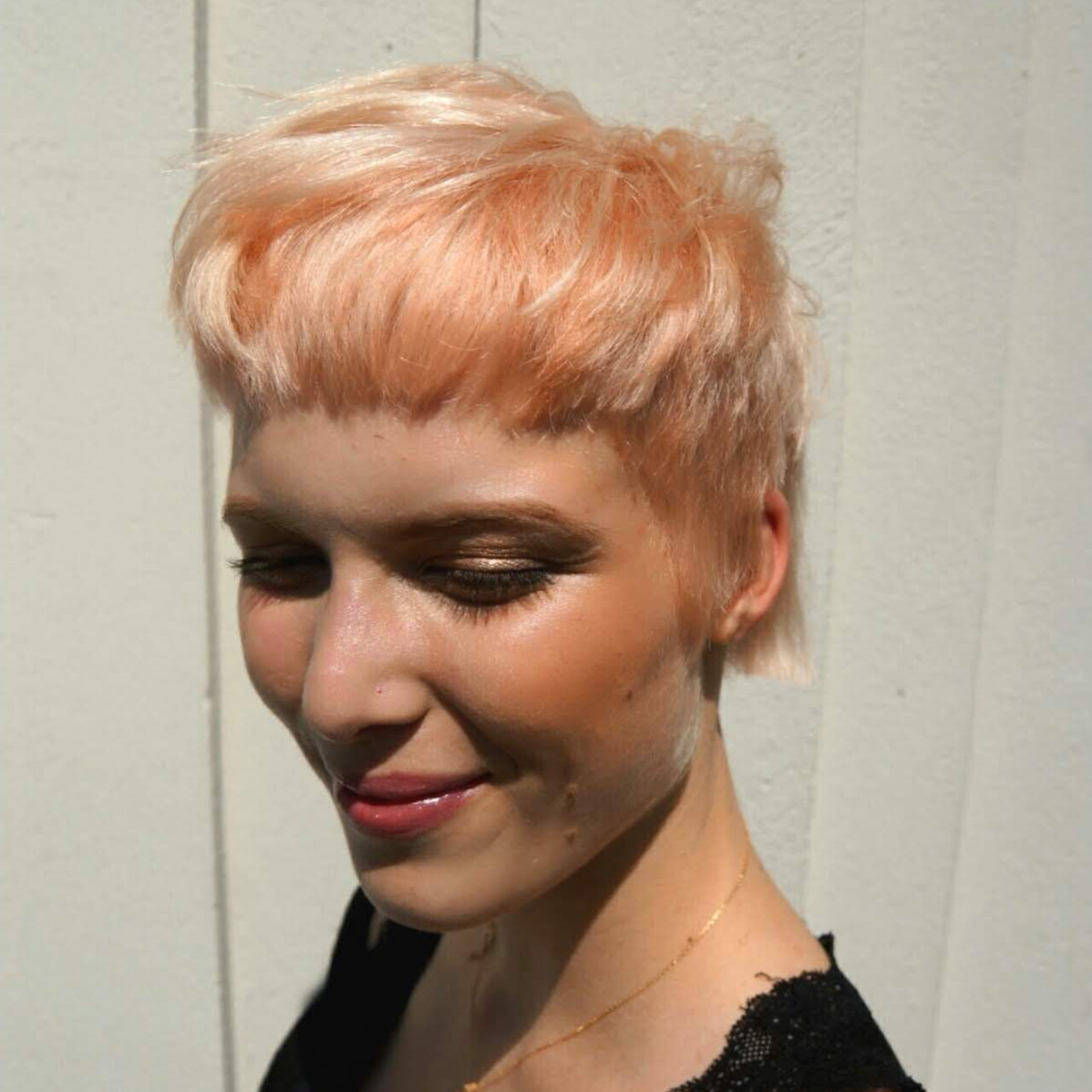 Woman with short, styled hair against a neutral background