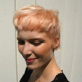Woman with short, styled hair against a neutral background