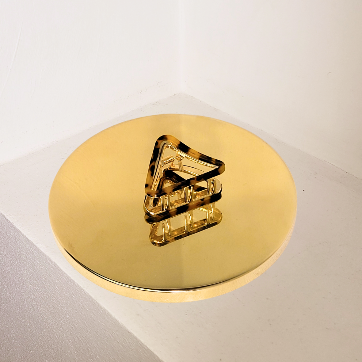A dark tortoiseshell-colored hair clip made of plant-based celluloid acetate, displayed on a light surface.