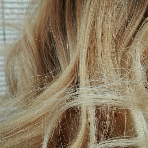 Close-up of wavy blonde hair with a blurred background