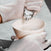 Person wearing gloves pouring hair dye cream from a tube into a pink bowl.