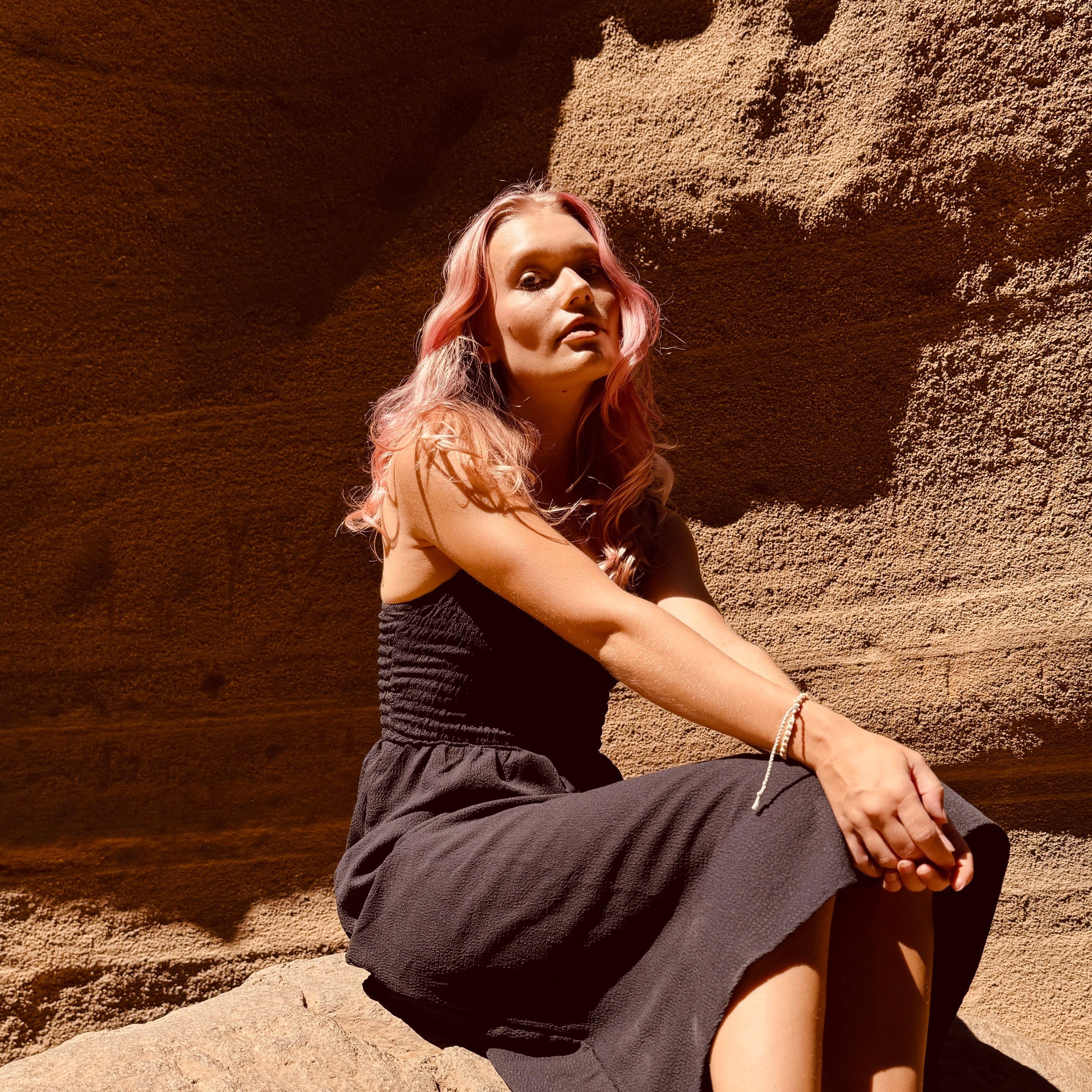 Woman sitting on a rock in a natural cave setting